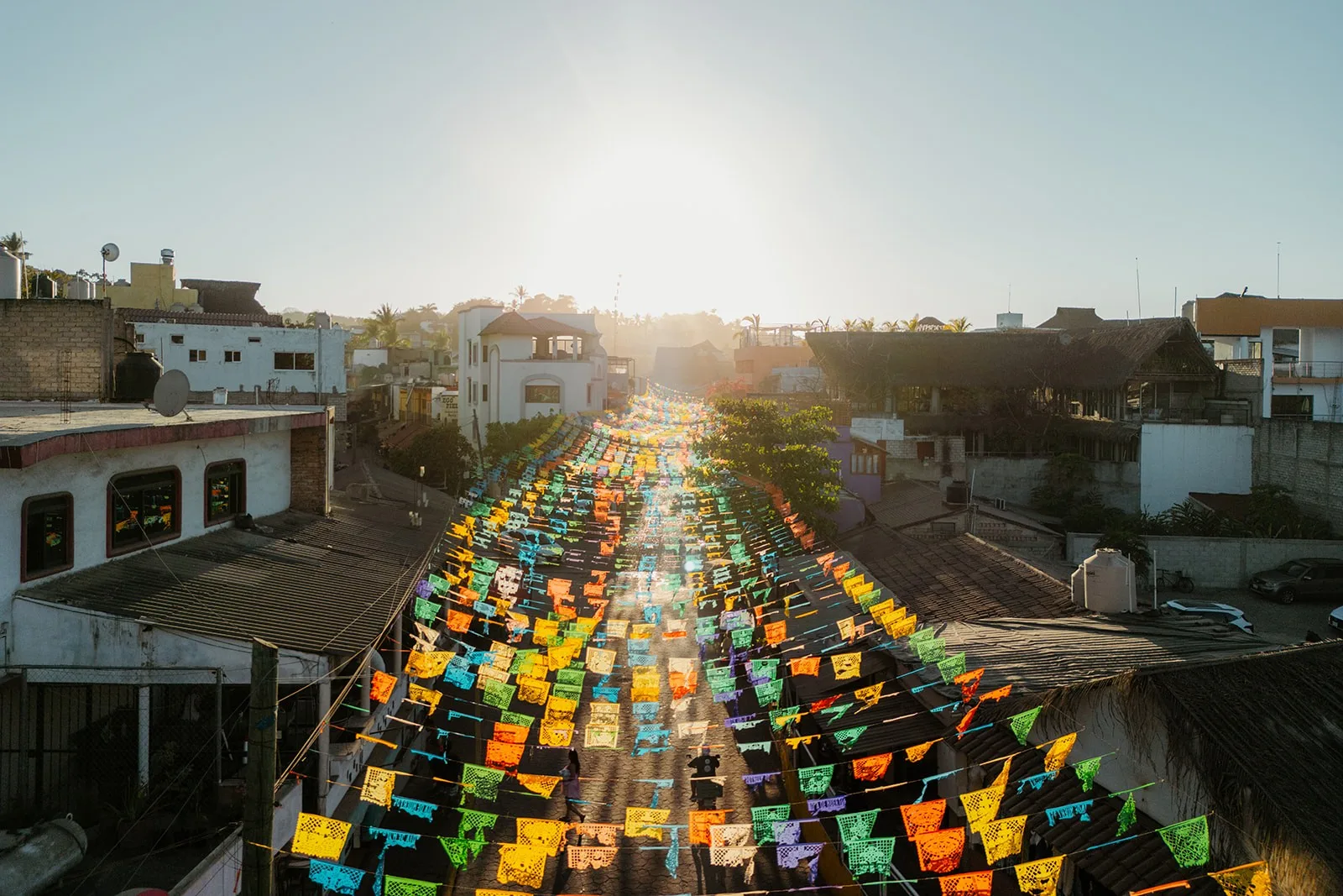 A Sayulita street strung with papel picado at sunset