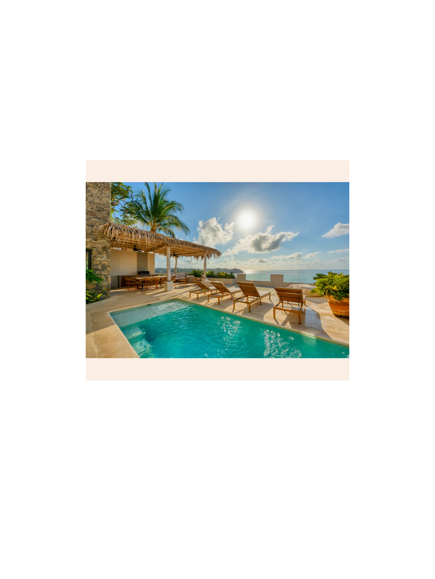 A pool terrace over the ocean, framed by jungle